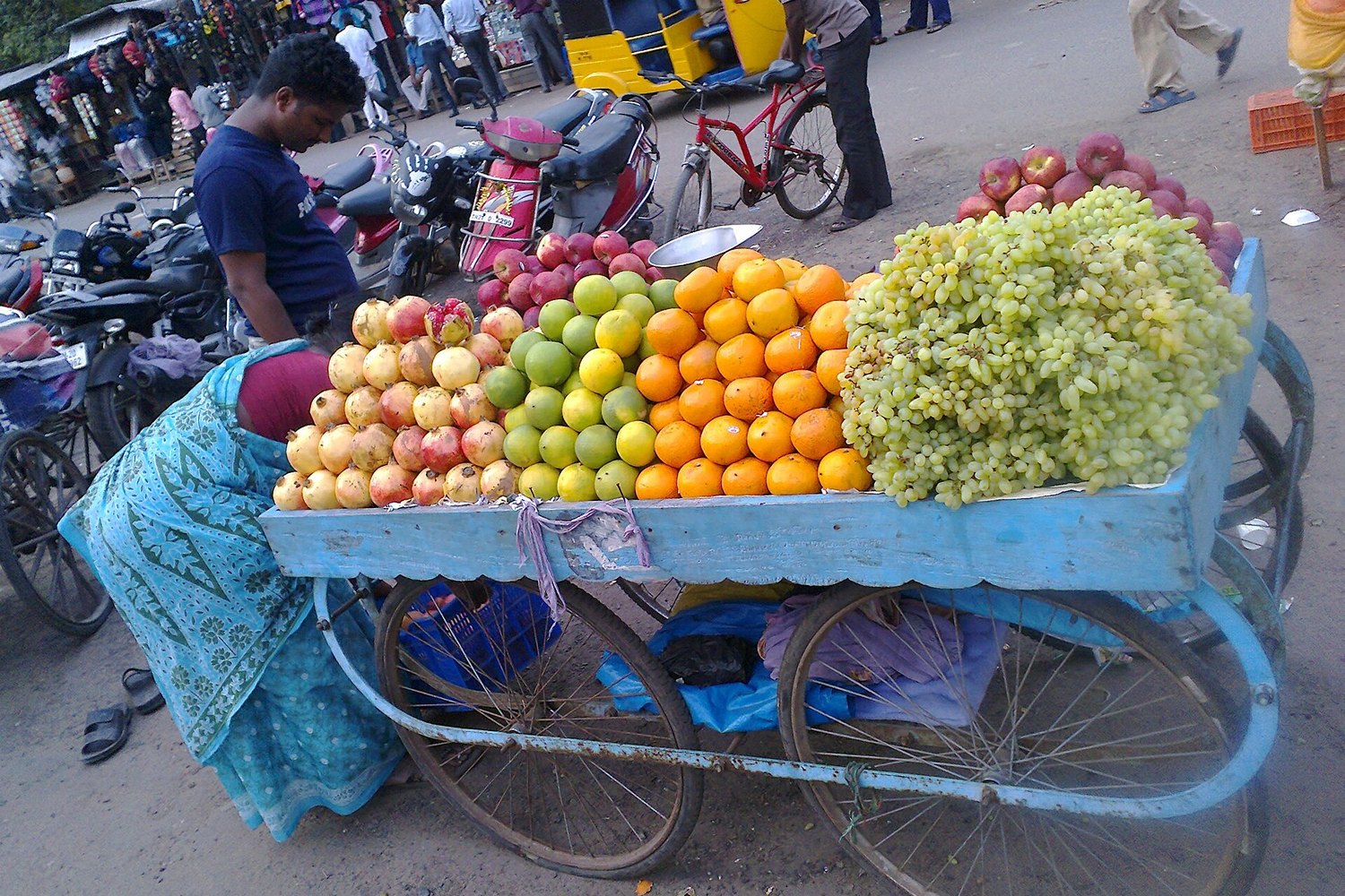 A street vendor selling fruit at a market in India